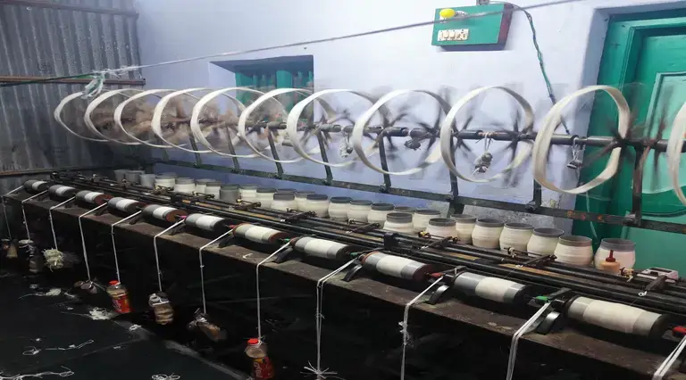 Mechanical and human based spinning of cotton fibres from yarn to cone